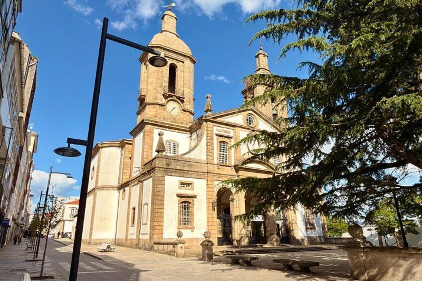 A historic church with a bell tower, a large arched doorway, and a clock. 2