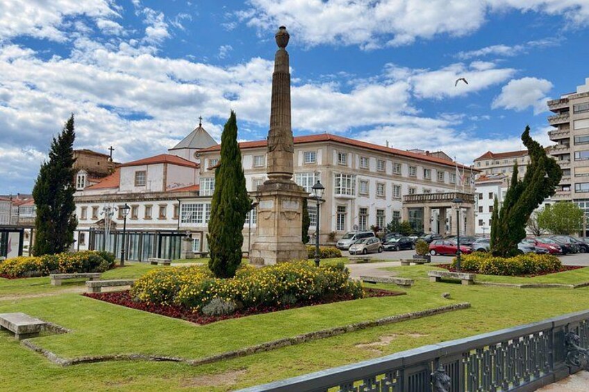 A monument in a landscaped area with buildings in the background. 5