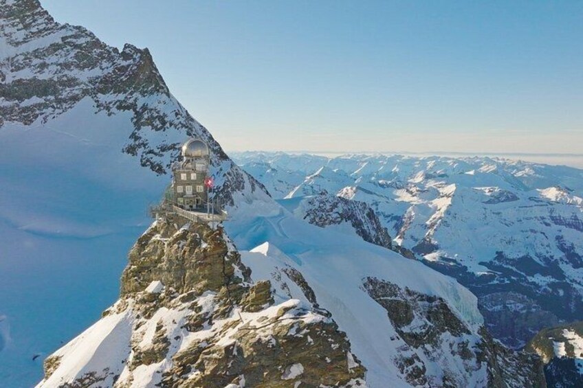A snow-covered mountain peak with a small observatory or lookout tower. 4