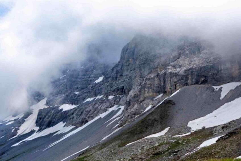A mountain landscape with snow patches and rocky terrain. 5