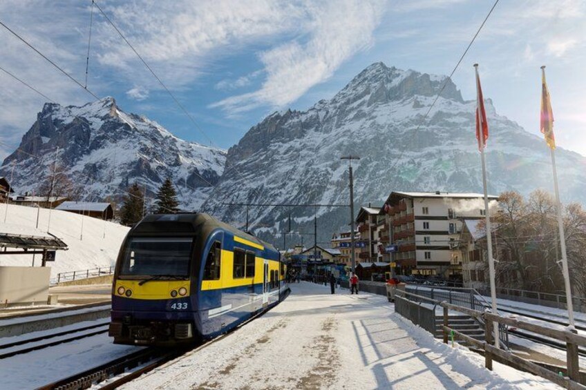 A train on tracks with a mountainous backdrop. 2