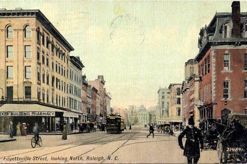 A street scene with buildings, a trolley, and a horse-drawn carriage. 3
