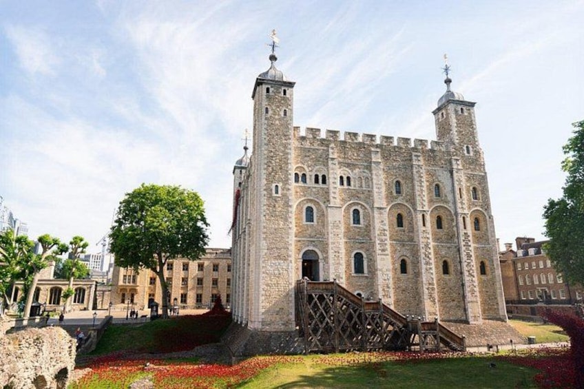 A historic stone castle with two towers, a central courtyard, and a staircase leading to the entrance. 3