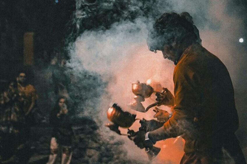 A person holding a cup and a smoking device, surrounded by smoke. 2