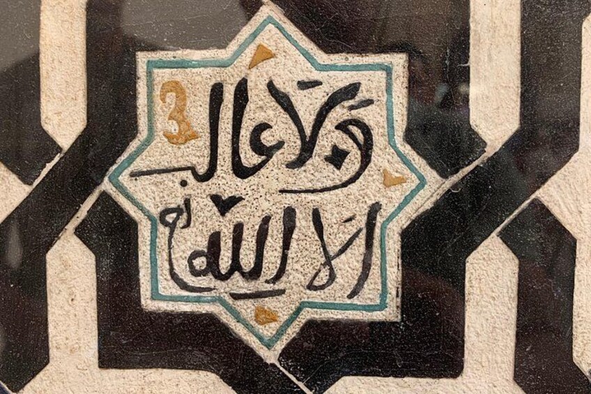 A geometric tile with Arabic calligraphy. 3