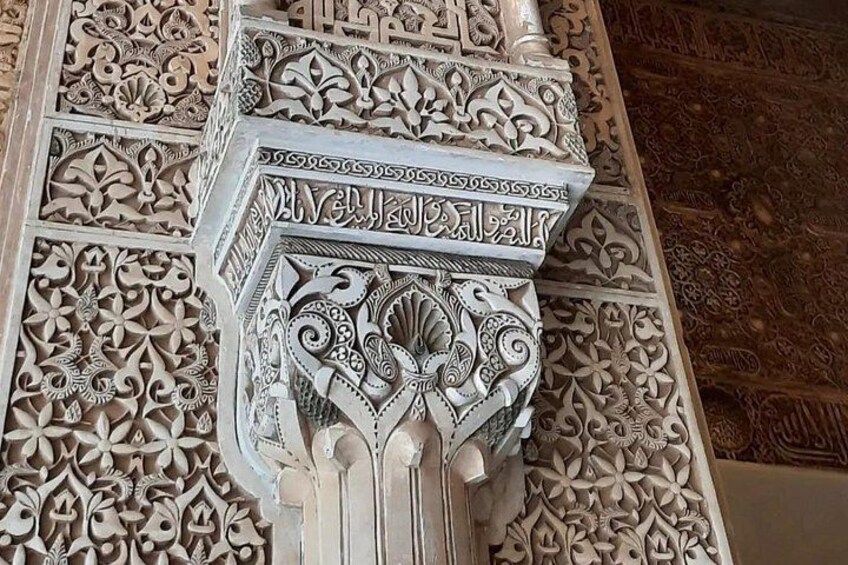 A detailed carved architectural column with intricate patterns and Arabic calligraphy. 2