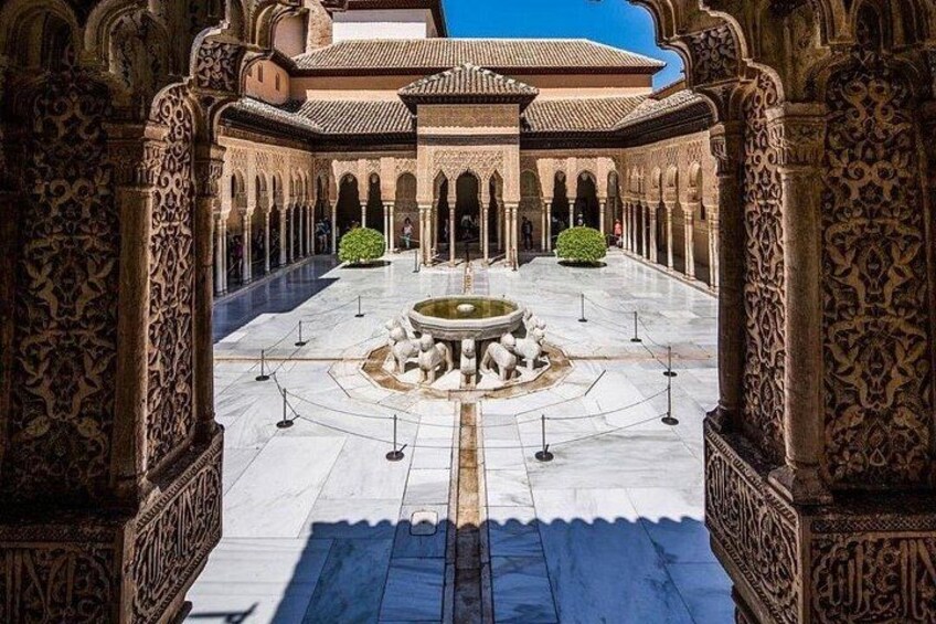 An ornate courtyard with intricate arches and a central fountain. 1