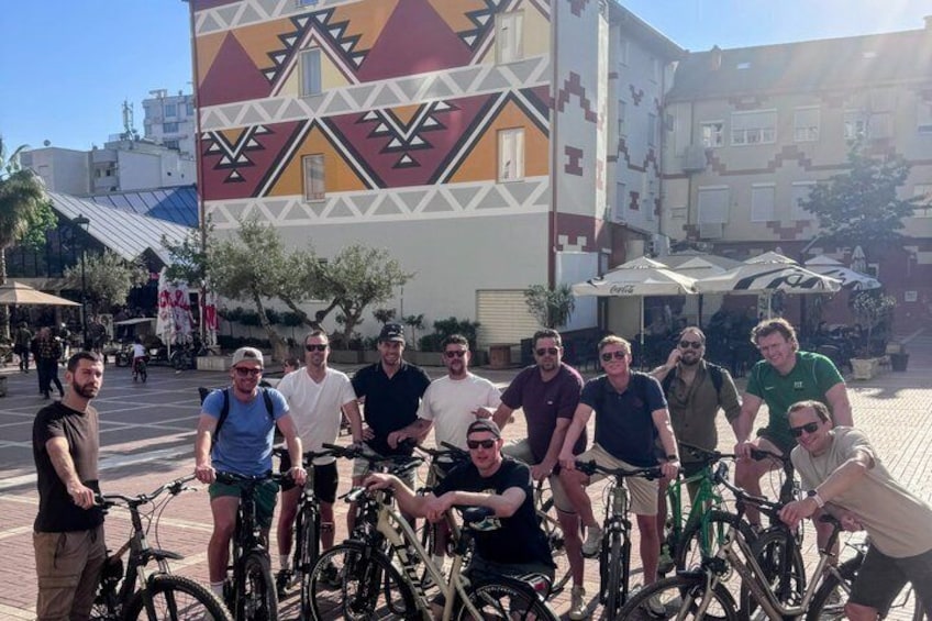 A group of people with bicycles in an outdoor urban setting. 2