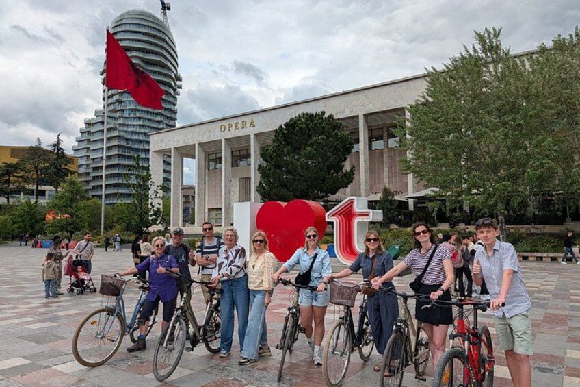 Un groupe de personnes à vélo se trouve devant un bâtiment sur lequel on peut lire l’inscription « Opéra ». 1