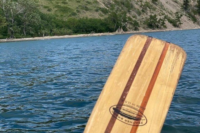 A wooden paddle in water with a label that reads 'Made in USA.' 4