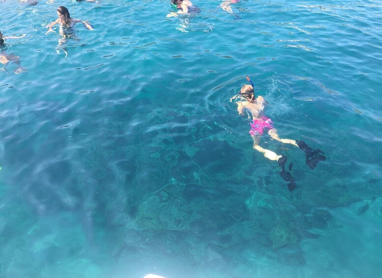 A person swimming in clear blue water. 4