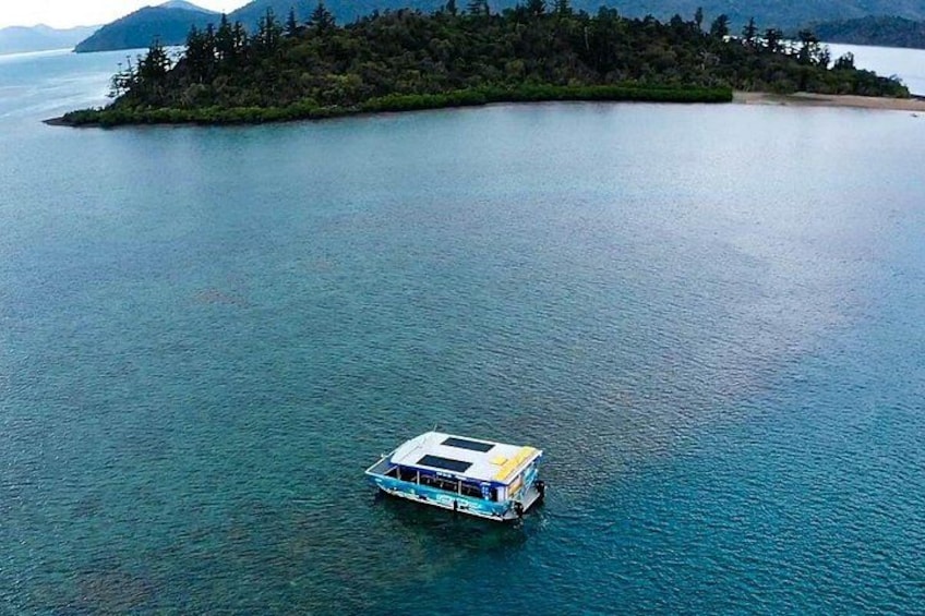 A boat on a calm lake surrounded by forested islands. 4