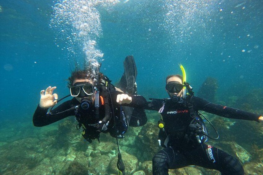 Two scuba divers underwater with fins and scuba gear. 2