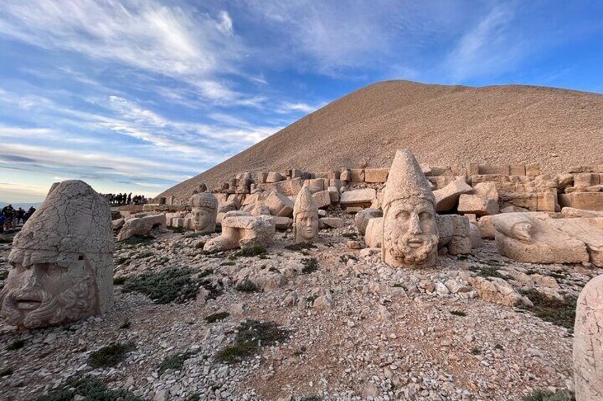 Ancient stone statues and ruins in a desert landscape. 5