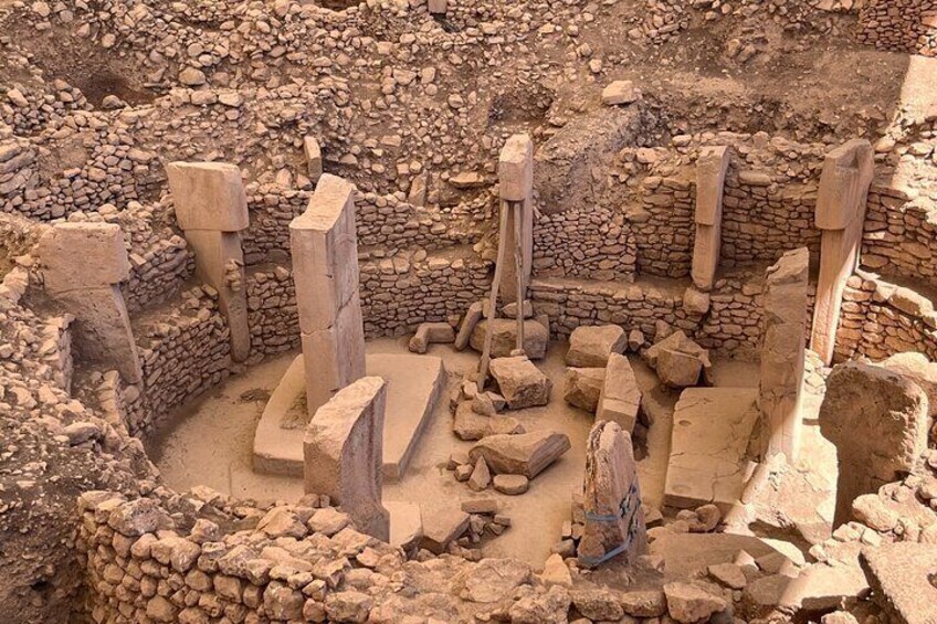 Ancient stone structures with a circular layout, surrounded by a stone wall. 3