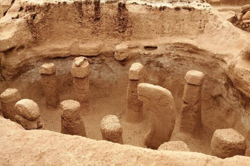 A large, ancient stone structure with multiple vertical pillars and a central depression. 2