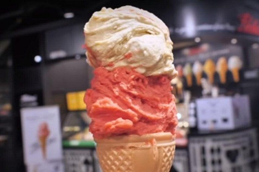 A scoop of ice cream in a waffle cone with a blurred background. 2