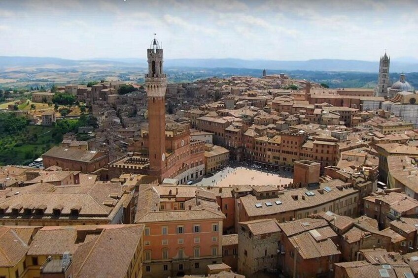 A historic cityscape with prominent towers and a central square. 1