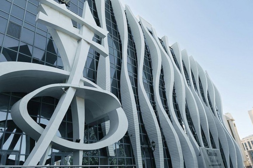A modern building with a unique curved facade and large glass windows. 1