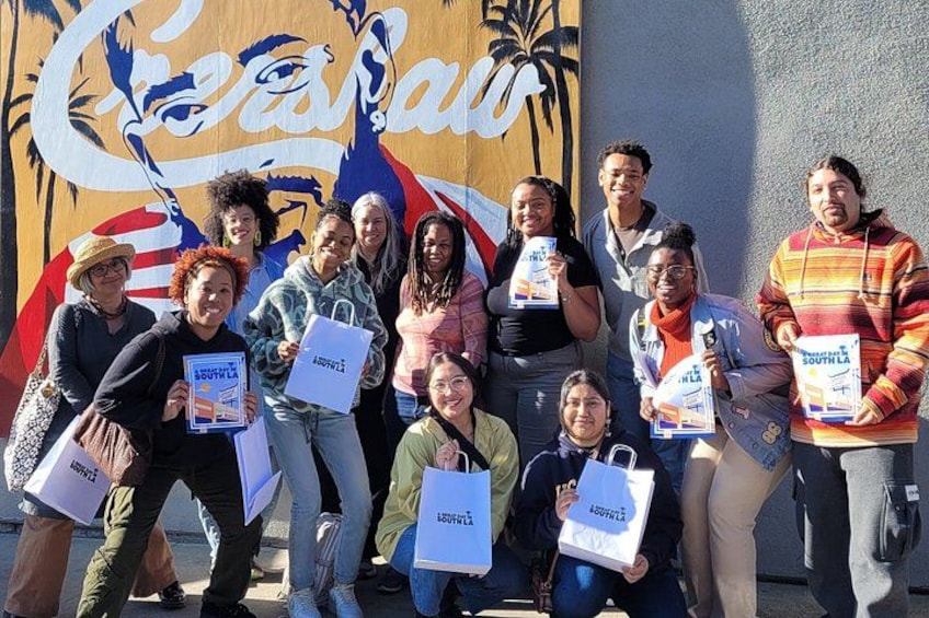A group of people holding signs in front of a mural. 5