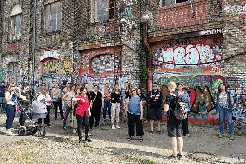 En grupp människor som står framför en vägg täckt av graffiti. 2