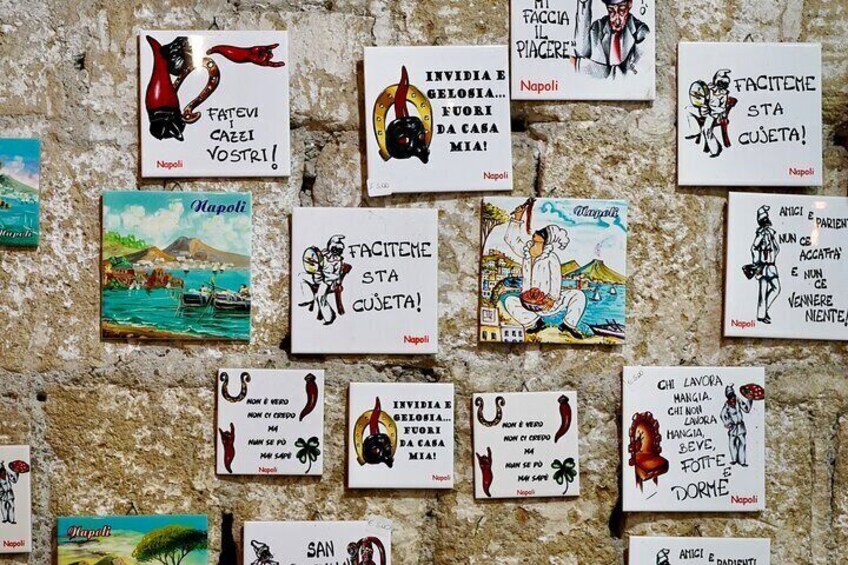 A wall with various postcards pinned to it, each featuring different illustrations and text. 2