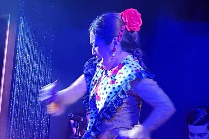 A person performing a dance with a polka dot and floral patterned outfit. 2