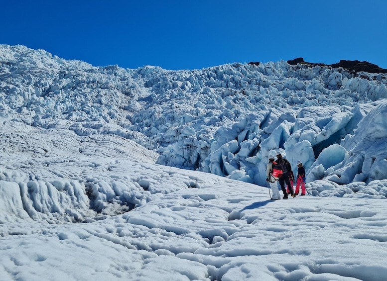 A glacier with people walking on it. 5