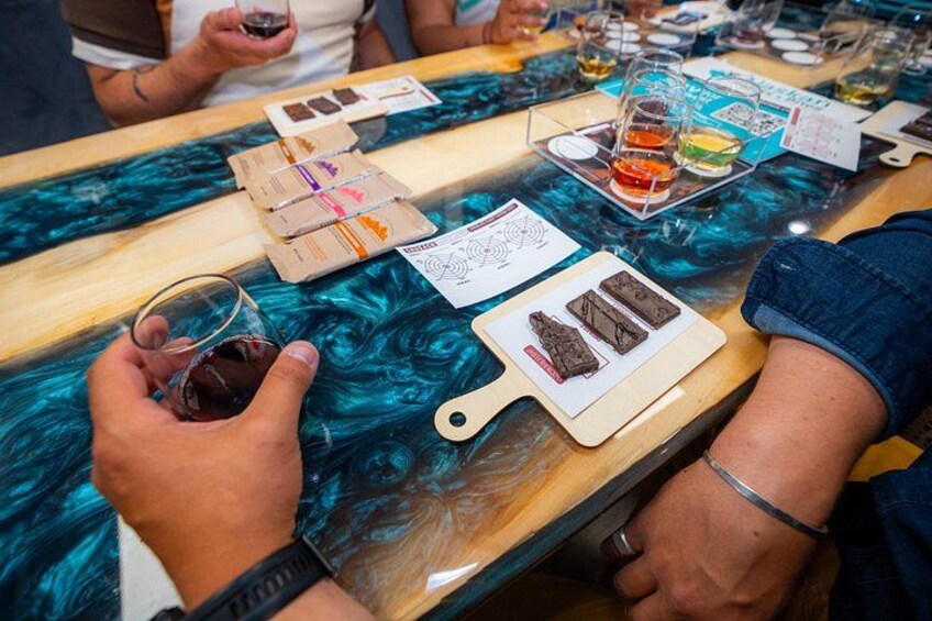 Una persona sosteniendo una copa de vino tinto en un bar con una barra de mármol azul. 5