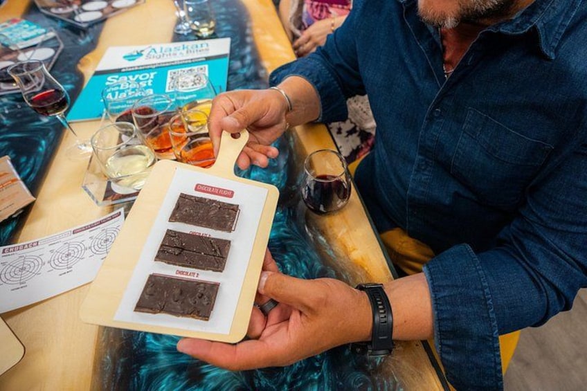 Una persona sostiene una tabla de madera con tres brownies de chocolate. 1