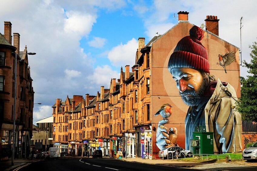 A street with buildings, a mural, and a bird. 2