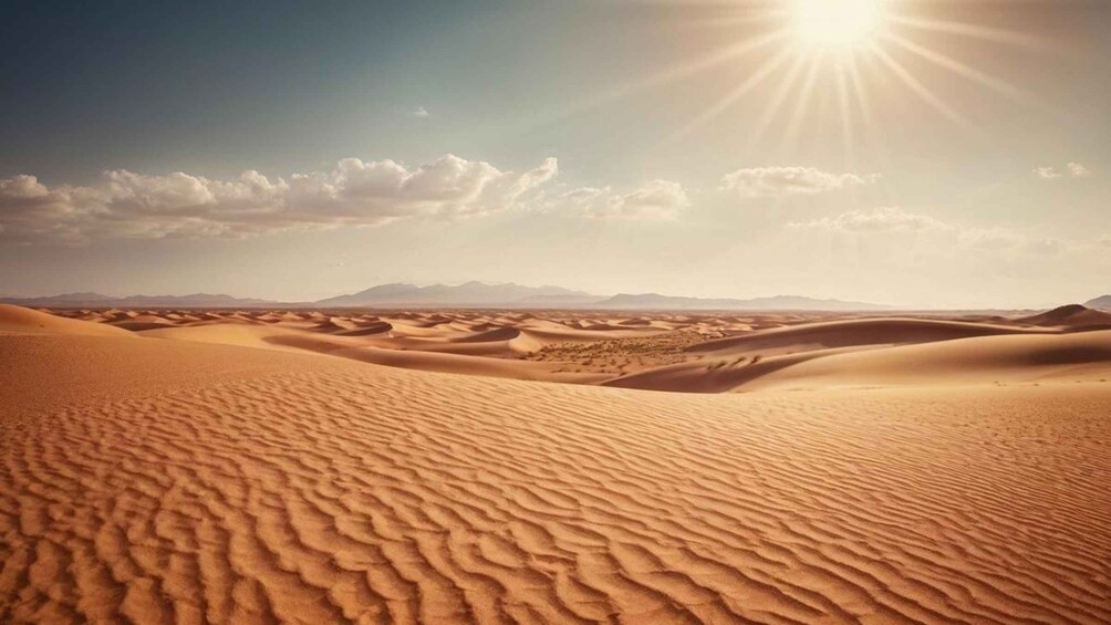 A desert landscape with sand dunes under a clear sky and the sun shining. 2