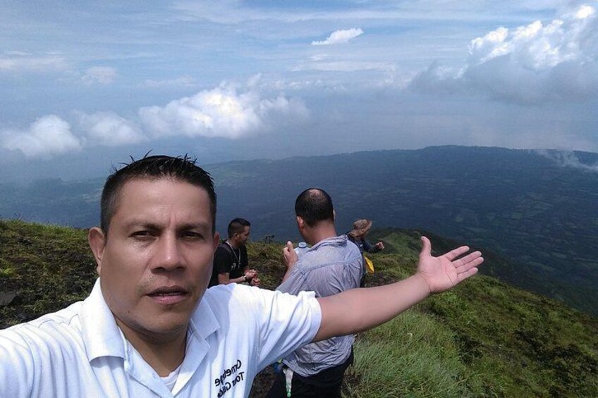 A person taking a selfie with a mountainous landscape in the background. 5