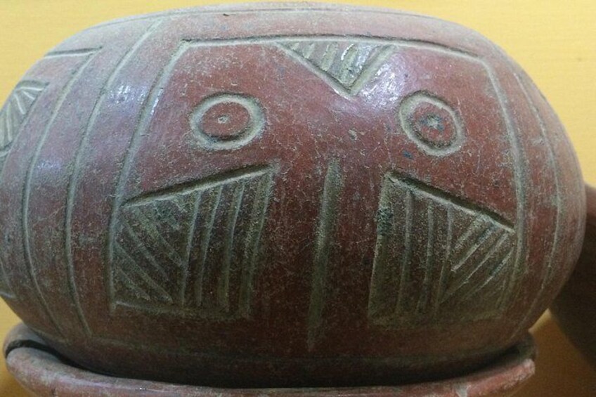 A carved stone with geometric patterns and circular indentations. 2