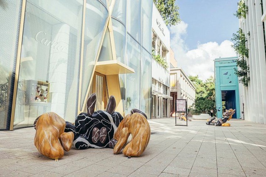 En gade med moderne arkitektur, en butik med blå facade og en skulptur af kaniner. 2