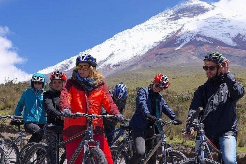 Un gruppo di persone in bicicletta con una montagna innevata sullo sfondo. 5