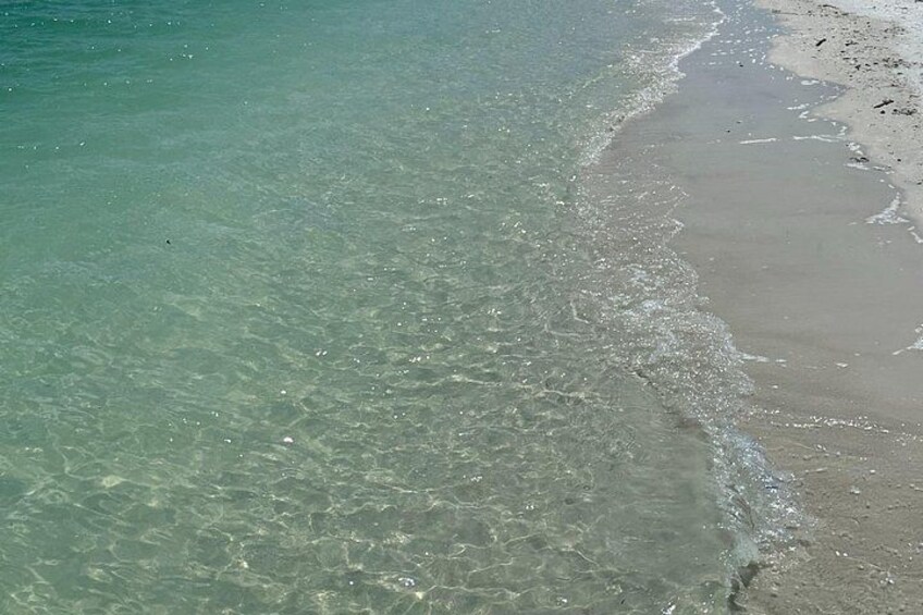 Une plage avec une eau claire et peu profonde et un rivage sablonneux. 3