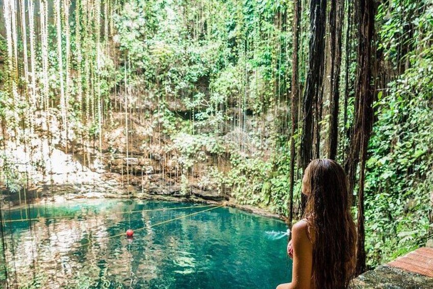 Una persona seduta accanto a una piscina limpida e blu, immersa nel verde e alberi. 2