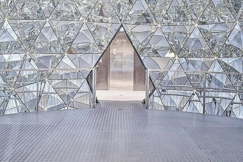 A geometric glass structure with a central elevator shaft. 2