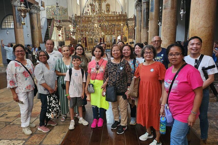 Een groep mensen in een kerk met versierde architectuur en een gouden altaar. 5