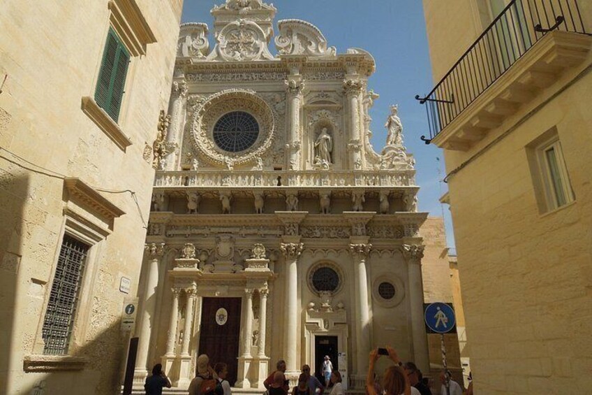 A historic building with ornate architecture, including a large circular window and statues. 1