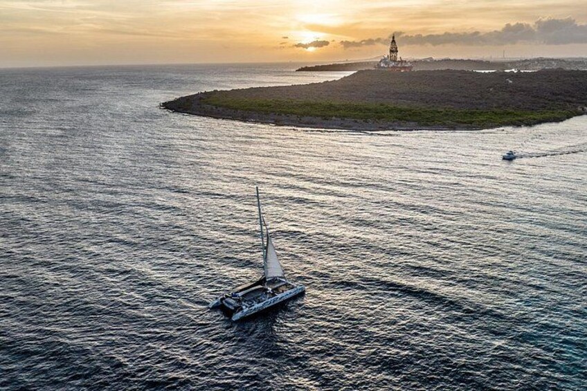 Een zeilboot op rustig water, met een vuurtoren op de achtergrond. 2