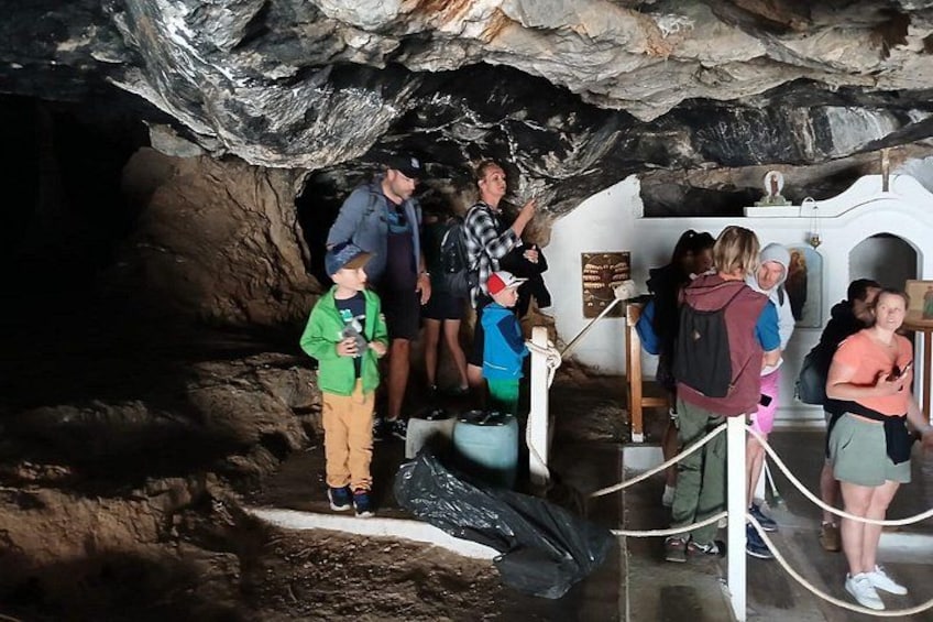 A group of people inside a cave with rocky walls and a white structure. 2