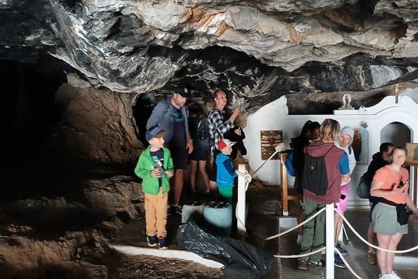 A group of people inside a cave with rocky walls and a white structure. 4