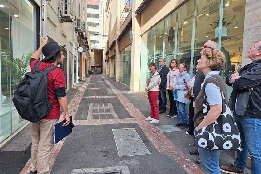 A group of people standing on a street, some looking at a map, others engaged in conversation. 5