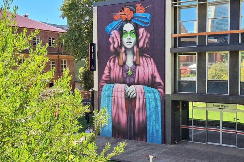 A mural of a woman in a colorful robe on a building. 4