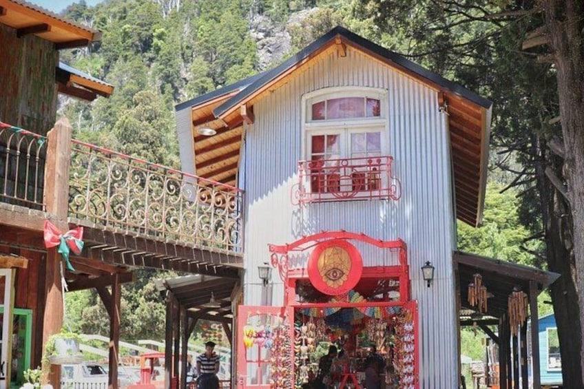 A rustic building with a balcony, a red decorative element, and a wooden structure. 2