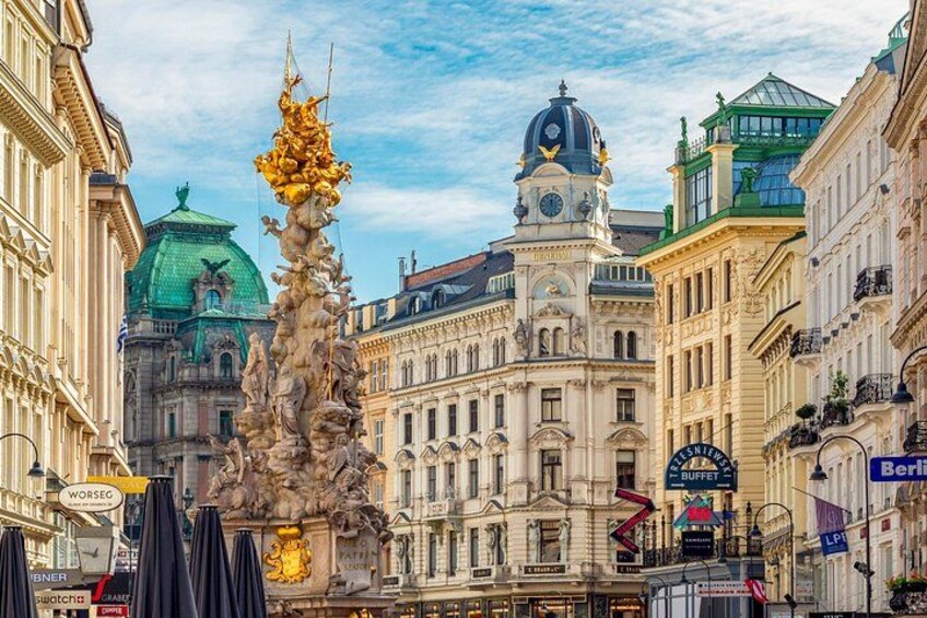 Ein historisches Gebäude mit einem Glockenturm, einer Statue und einer grünen Kuppel. 3