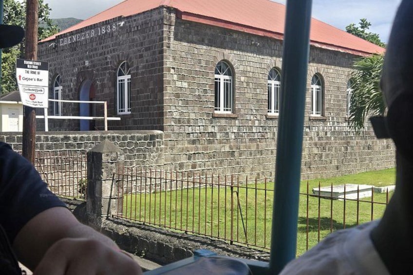 Un edificio de piedra con ventanas arqueadas y techo rojo. 3
