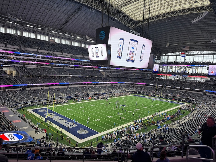 A football stadium with a large screen displaying advertisements, a Pepsi logo, and AT&T Stadium signage. 5